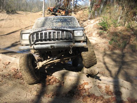 1987 Jeep Comanche - This 1987 Jeep Comanche navigates a challenging muddy off-road course, with another vehicle visible in the background.