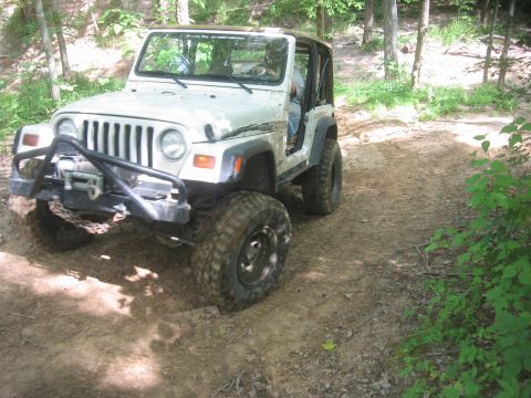 1987 Jeep Comanche - This Jeep Wrangler TJ navigates a wooded trail with its front end angled towards the camera.