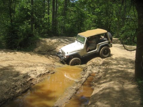 1987 Jeep Comanche - Jeep Wrangler tackling a muddy off-road course.