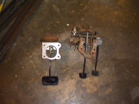 1991 Ford LTD Crown Victoria - Two different car pedal assemblies are shown on a concrete surface.