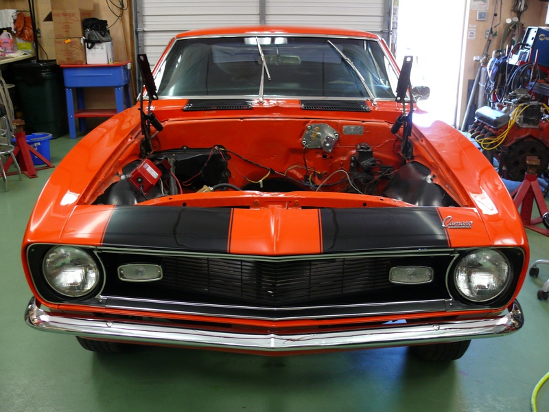 Orange 1968 Chevrolet Camaro front view, hood open, black racing stripes