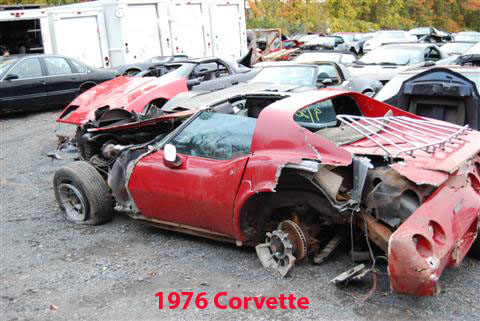 1976 Chevrolet Corvette - This heavily damaged 1976 Chevrolet Corvette is in a junkyard with other vehicles.