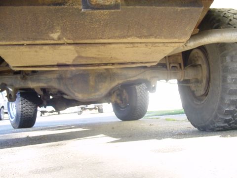 1987 Ford Bronco - The rear axle and suspension components of a 4x4 vehicle are visible from a low angle.