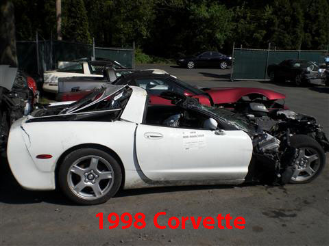 1976 Chevrolet Corvette - This severely damaged white Corvette, seen from the side, shows extensive front-end destruction. The visible text on the door confirms it i…