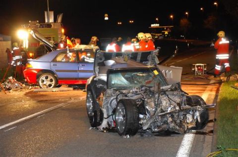 1976 Chevrolet Corvette - Emergency responders at a multi-vehicle accident scene at night, showing extensive damage to both cars.