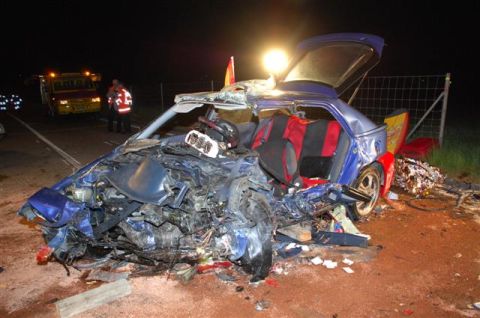 1976 Chevrolet Corvette - Car crash scene at night with emergency responders and a wrecked vehicle.