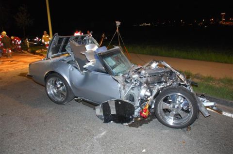 1976 Chevrolet Corvette - A severely damaged silver convertible sits on the side of the road at night, with emergency personnel present.