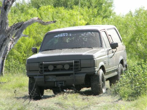 1989 Ford Bronco - This SUV is covered in mud, suggesting it has been off-roading.