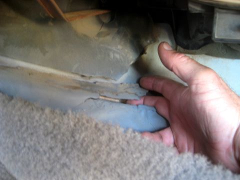 1996 Ford Bronco - Damage to the interior panel and exposed wiring are visible under the carpet.