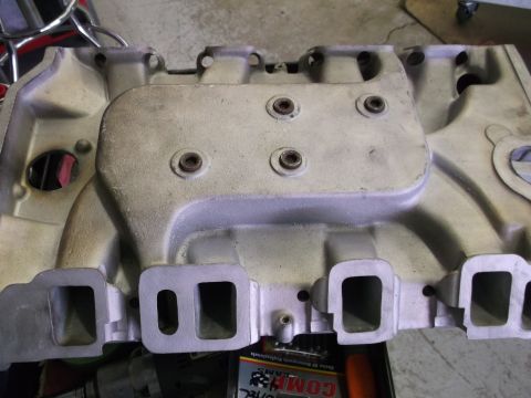 1967 Ford Mustang - An aluminum intake manifold is shown from a top-down perspective, with visible ports and fasteners.