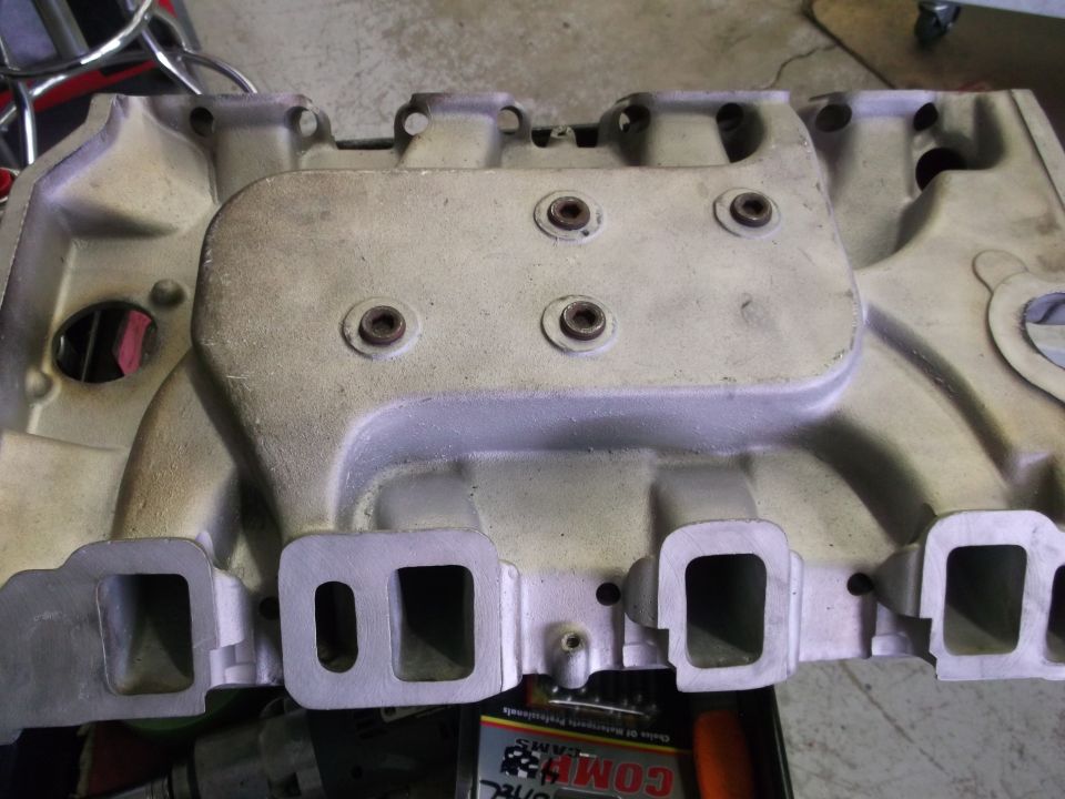 Aluminum intake manifold with four intake ports visible, some bolts in place