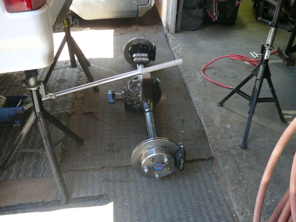 Rear axle assembly with disc brakes on jack stands in a garage