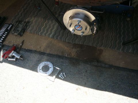 1988 Ford Bronco - Brake caliper and rotor assembly with tools laid out for installation.