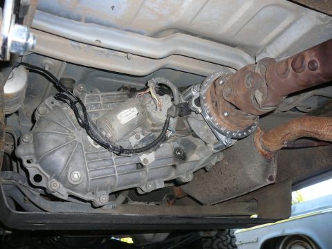 1988 Ford Bronco - Underside view shows the transfer case and driveshaft assembly of a vehicle.