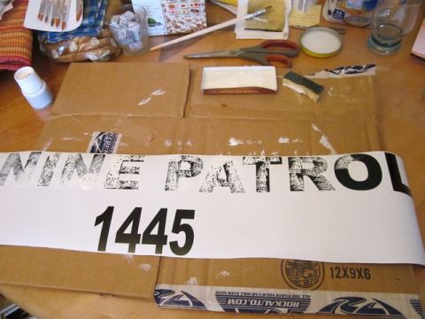 1991 Ford LTD Crown Victoria - A decal with "MINE PATROL 1445" and a SuperMotors logo is laid out on cardboard, surrounded by craft supplies.
