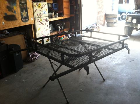1993 Jeep Cherokee - A metal roof rack is set up on a stand in a garage, with a Jeep partially visible in the background.