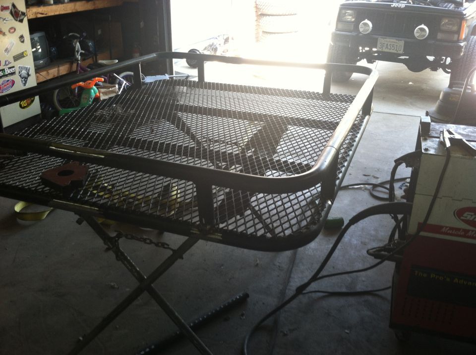 Custom roof rack frame on stand, welding equipment nearby
