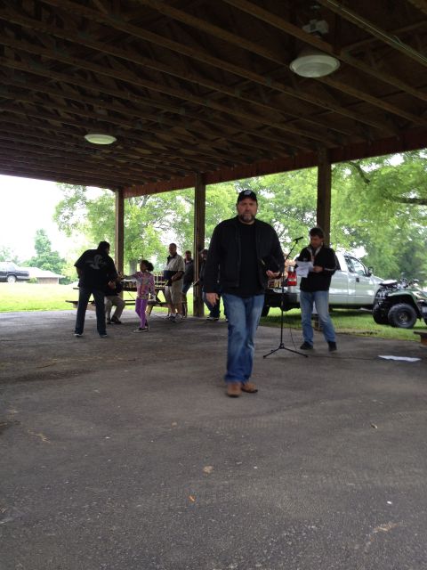 2007 Ford Mustang - A white pickup truck and an ATV are visible under a covered outdoor area with people gathered.