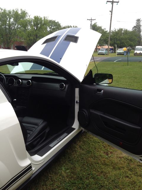 2007 Ford Mustang - White 2007 Ford Mustang with blue stripes, open hood and driver's door, showing black interior and SVT door sill.