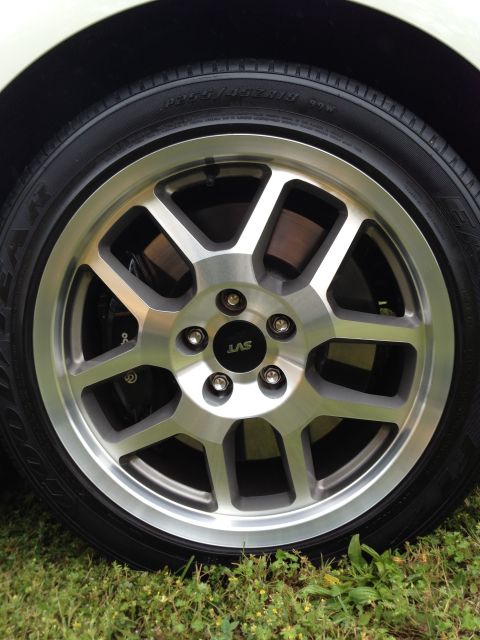 2007 Ford Mustang - A close-up view of a silver SVT wheel, revealing a black brake caliper behind the spokes.