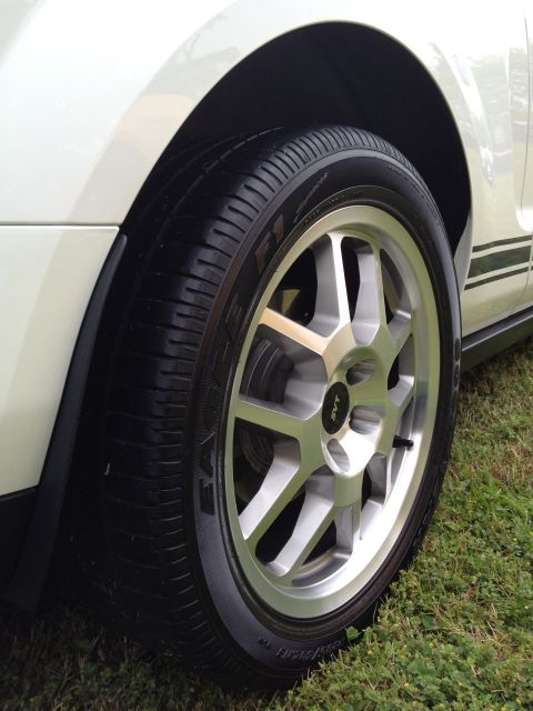 2007 Ford Mustang - Close-up of a silver SVT wheel and Eagle tire on a white car with black stripe.