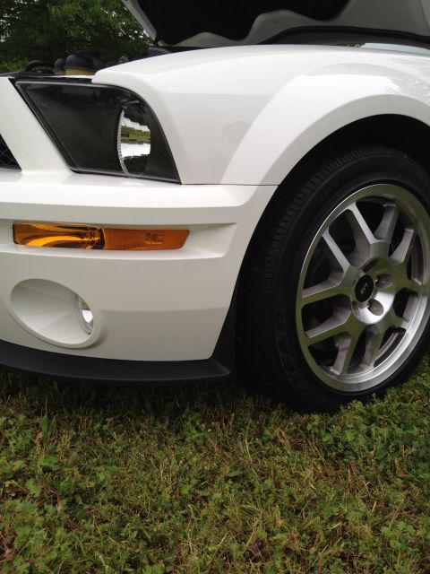 2007 Ford Mustang - Front corner view of a white 2007 Ford Mustang, with the hood raised, revealing the engine bay.