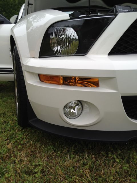 2007 Ford Mustang - Close-up of a white Ford Mustang's front end, showing the grille and headlights with the hood raised.
