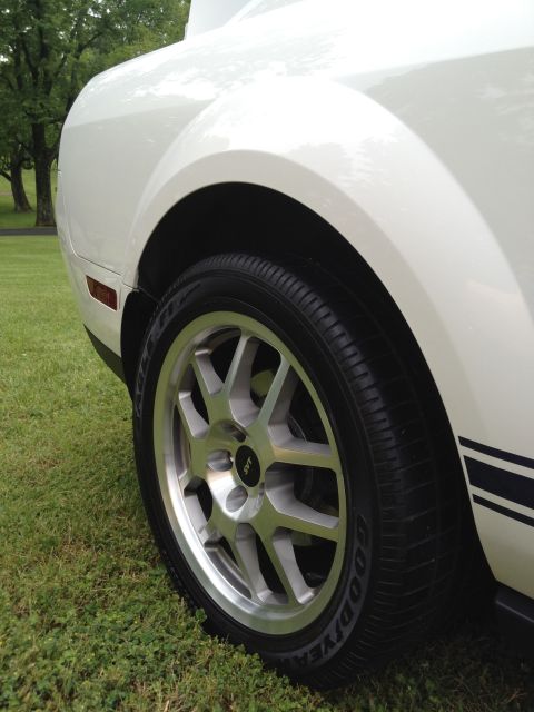 2007 Ford Mustang - Close-up of a white 2007 Ford Mustang's rear wheel and quarter panel with SVT badging.