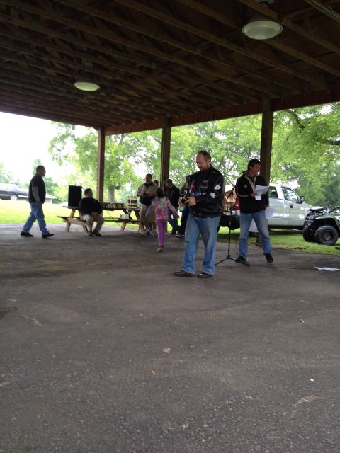 2007 Ford Mustang - An outdoor gathering with several people milling about under a pavilion.