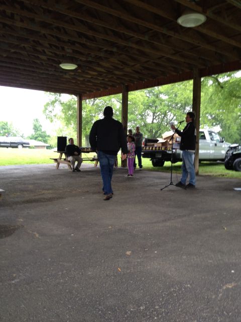 2007 Ford Mustang - A group of people are gathered under a covered pavilion, with a white pickup truck visible in the background.