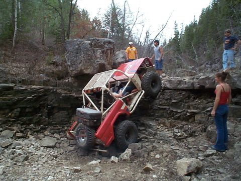 1977 Ford Bronco - An off-road vehicle navigates a challenging rocky terrain with spectators observing the action.