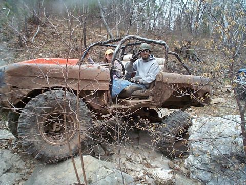 1977 Ford Bronco - This heavily modified off-road vehicle navigates a challenging rocky trail.
