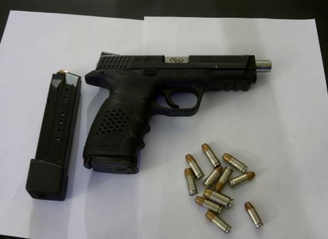 2000 Mercury Grand Marquis - A handgun, its magazine, and several rounds of ammunition are laid out on a white surface.