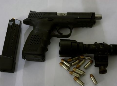 2000 Mercury Grand Marquis - A handgun, magazine, flashlight, and ammunition are laid out on a flat surface.