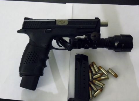 2000 Mercury Grand Marquis - A black pistol is shown with a tactical flashlight attached and a magazine with several rounds of ammunition nearby.