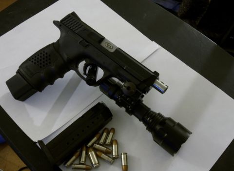 2000 Mercury Grand Marquis - Pistol with attached flashlight and ammunition laid out on a table.