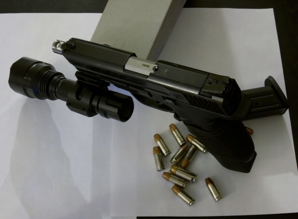 pistol with mounted flashlight and loose bullets