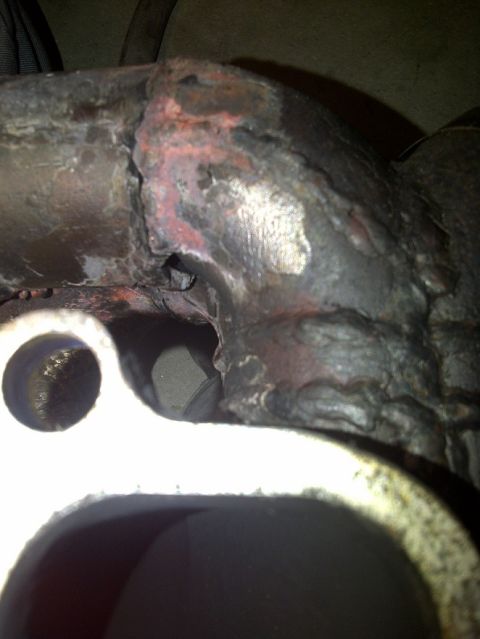 1995 Ford Probe - Close-up view of a damaged exhaust manifold, showing signs of wear and tear.