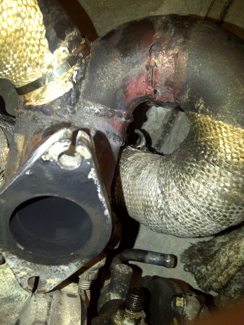 1995 Ford Probe - Close-up view of exhaust manifold and turbocharger piping, showing heat shielding and connections.