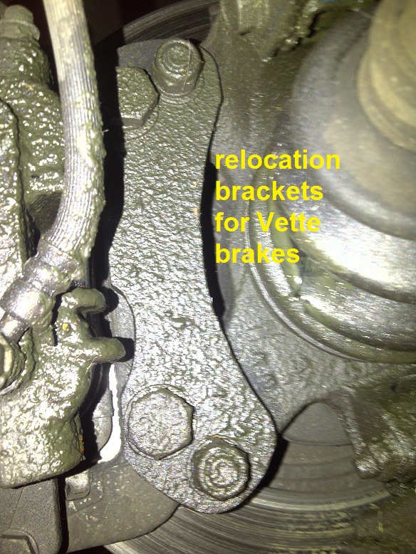 Close-up of a relocation bracket for Vette brakes, bolted to a vehicle's brake assembly