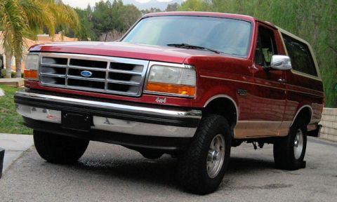 1994 Ford Bronco - Front 3/4 view of a red 1994 Ford Bronco with tan lower trim.