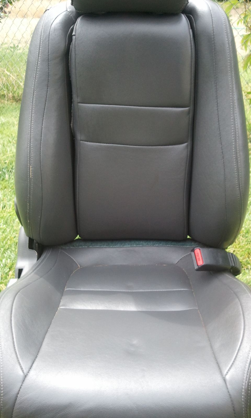 Black leather car seat with headrest and seatbelt