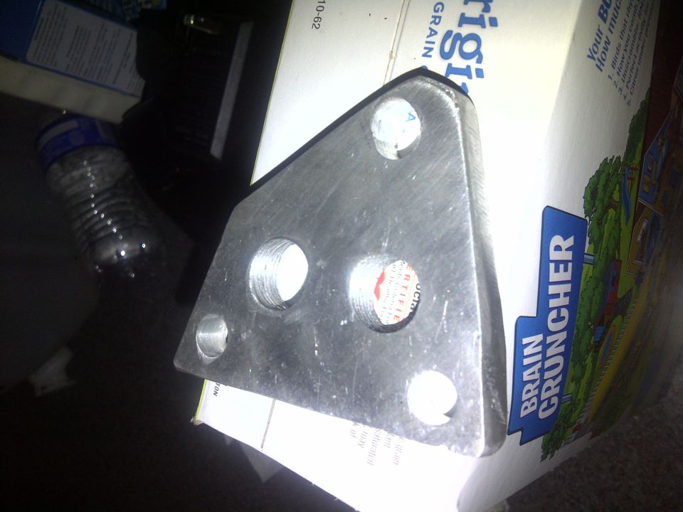 Metal bracket with four holes sitting on a box of cereal