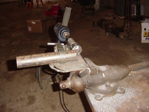 1992 Ford Bronco - Pipe cutting setup in a workshop with a vise and drill.
