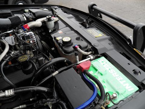 2003 Ford Crown Victoria - Engine compartment detail with a green Interstate battery and custom braided hoses.