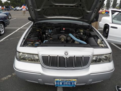2003 Ford Crown Victoria - Front of a silver Mercury, hood up exposing engine, Nevada plate reads DEWGONG.