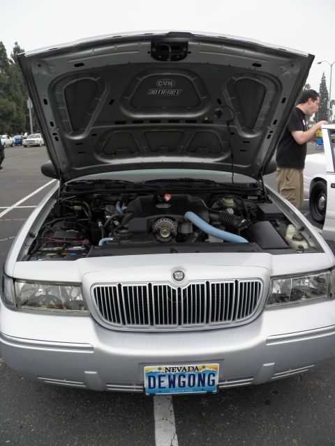 2003 Ford Crown Victoria - Vertical view of a silver Mercury, hood open showing engine, Nevada DEWGONG plate at front.