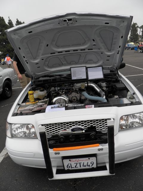 2003 Ford Crown Victoria - White Crown Victoria interceptor with brush guard and open hood, California plate 6LZT449.