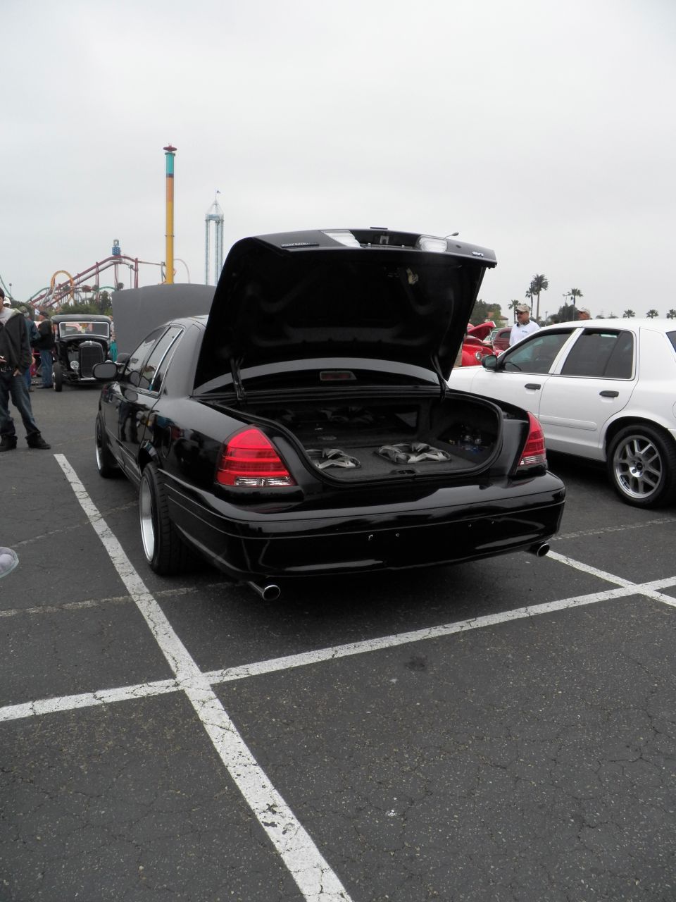 Black Ford Crown Victoria with open trunk showing subwoofers at car show
