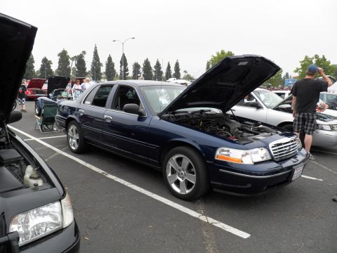 2003 Ford Crown Victoria - Navy Crown Victoria parked with hood raised, sitting on five-spoke alloys, crowd nearby.